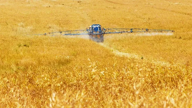 Rolnik wykonujący oprysk roślin w polu o poranku